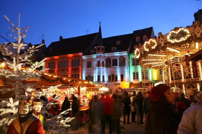 christmas market outdoor with several people and christmas lights.