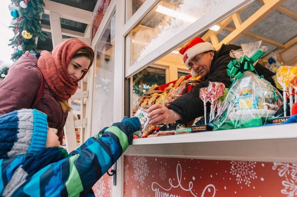 kid with a girl buying sweets during christmas.