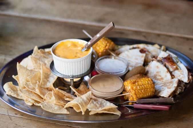 nachos with different dips and with corn.