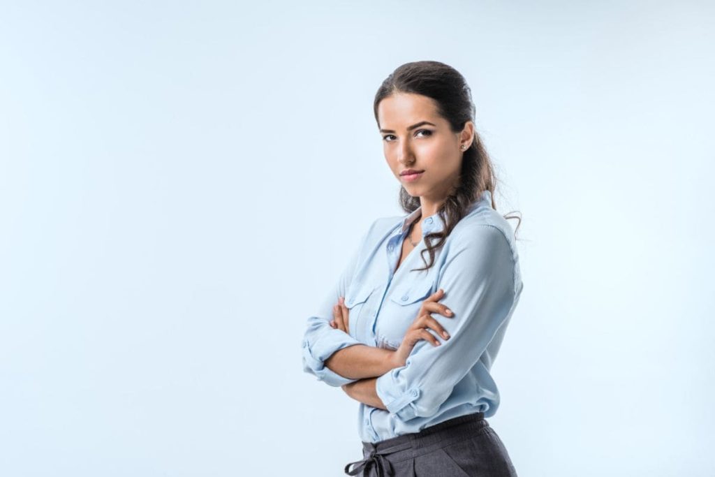 corporate woman wearing blue blouse and crossing arms.