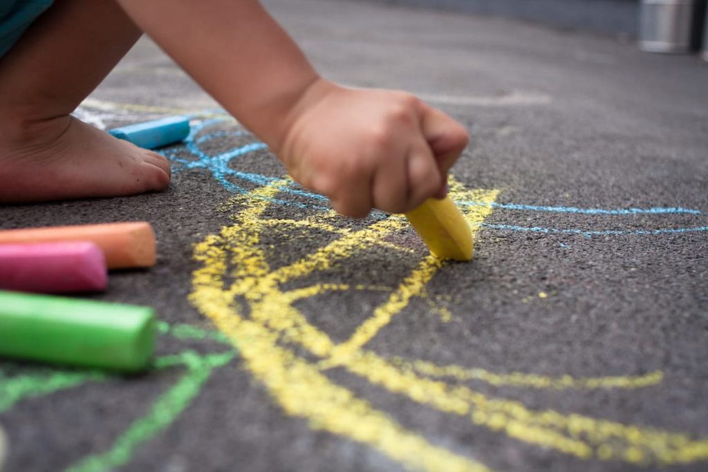 kid playing with sidewalk chalk.