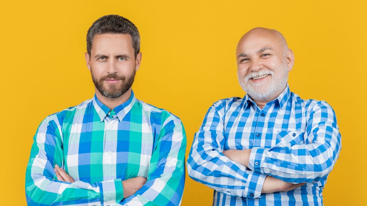 two men in checked looking at the camera in yellow background.