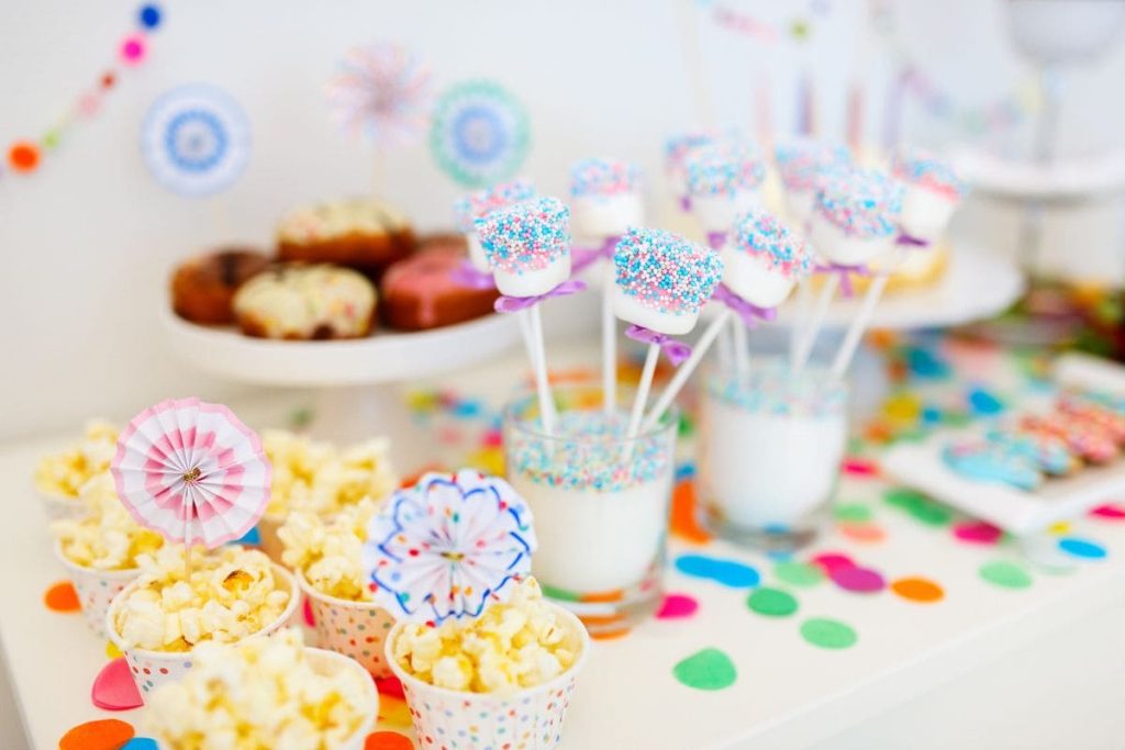 Colorful decoration of kids birthday party table with marshmallows and sweets.