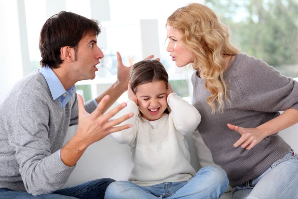 Couple fighting in front of child.