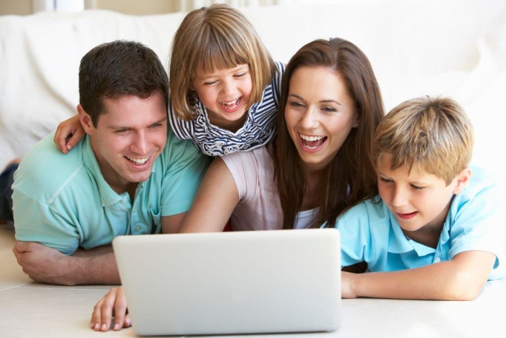 Young parents, with children, on laptop computer.