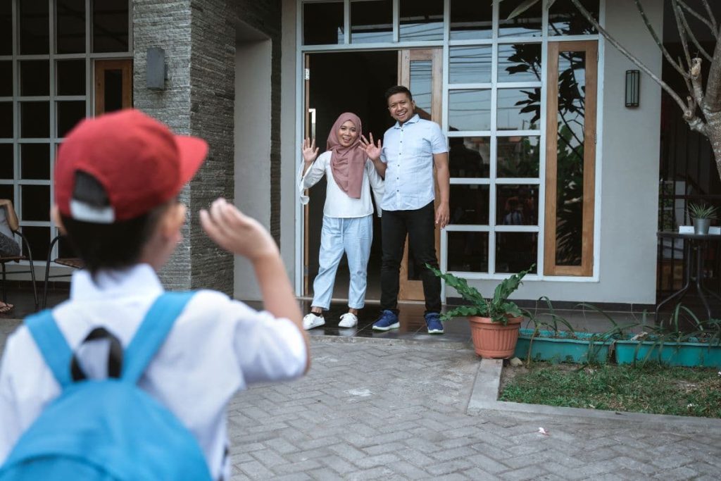 kid waving goodbye to parent before leaving to school.