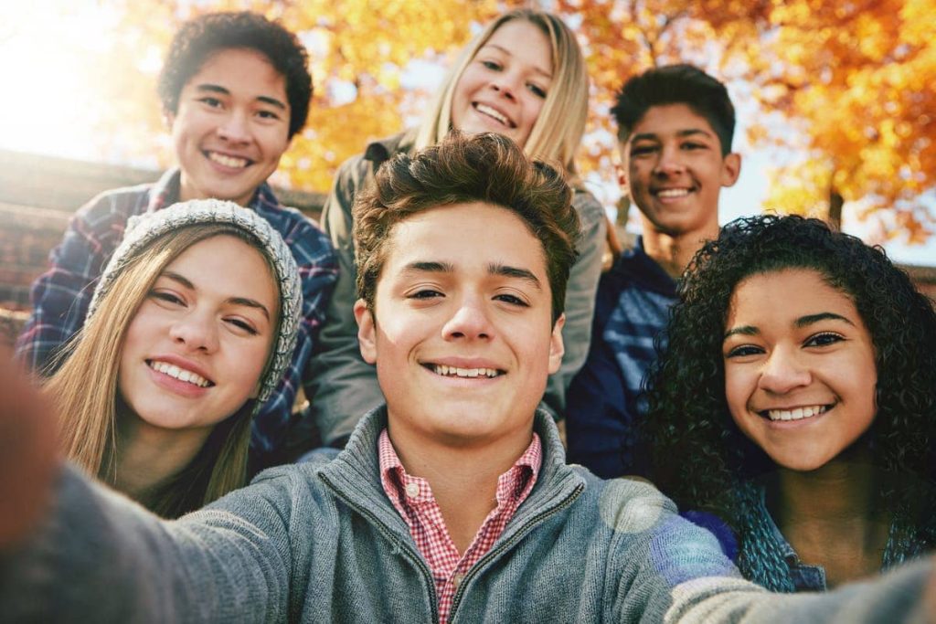 group of teenagers taking a selfie.
