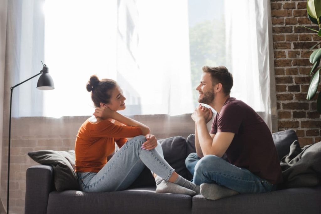 man and woman sitting on a sofa and chatting.