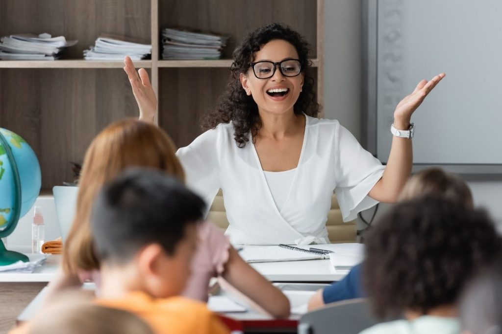 smiling female teacher while teaching students.