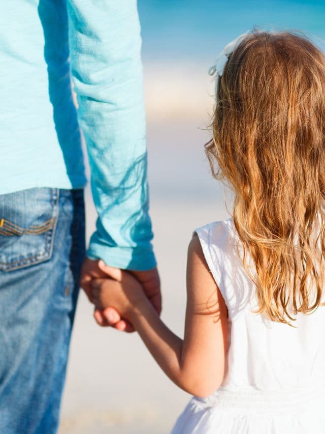 Adorable little girl holding her father hand.