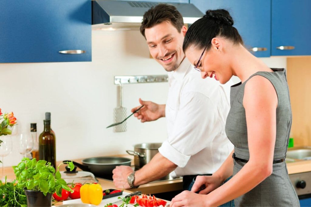 Couple happily cooking together.