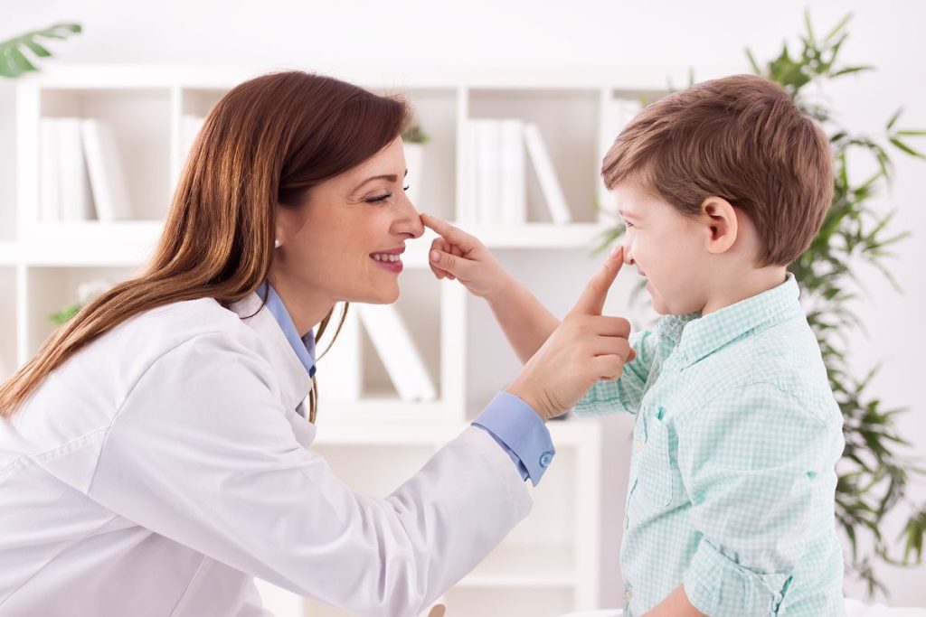Young doctor and child enjoy and playing together touching noses.