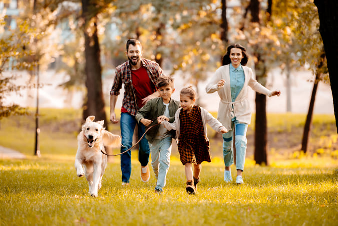 Family running outside in the grass.