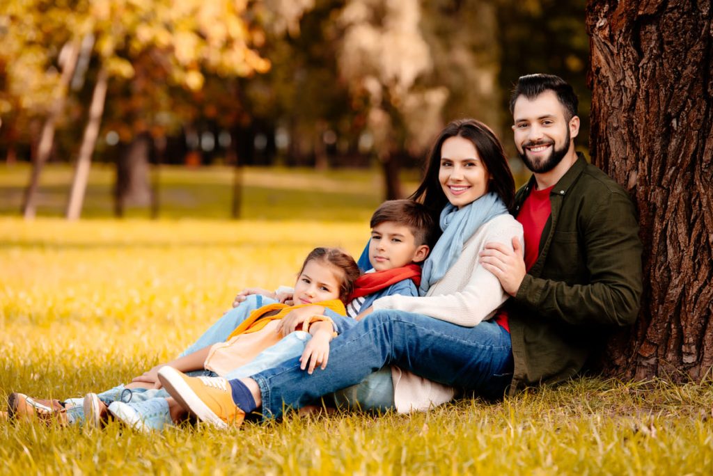 Family with kids next to a tree.