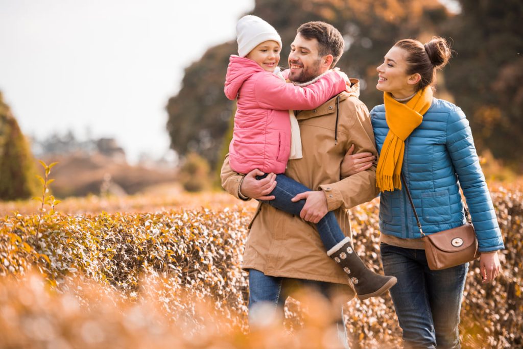 Happy family walking in park.