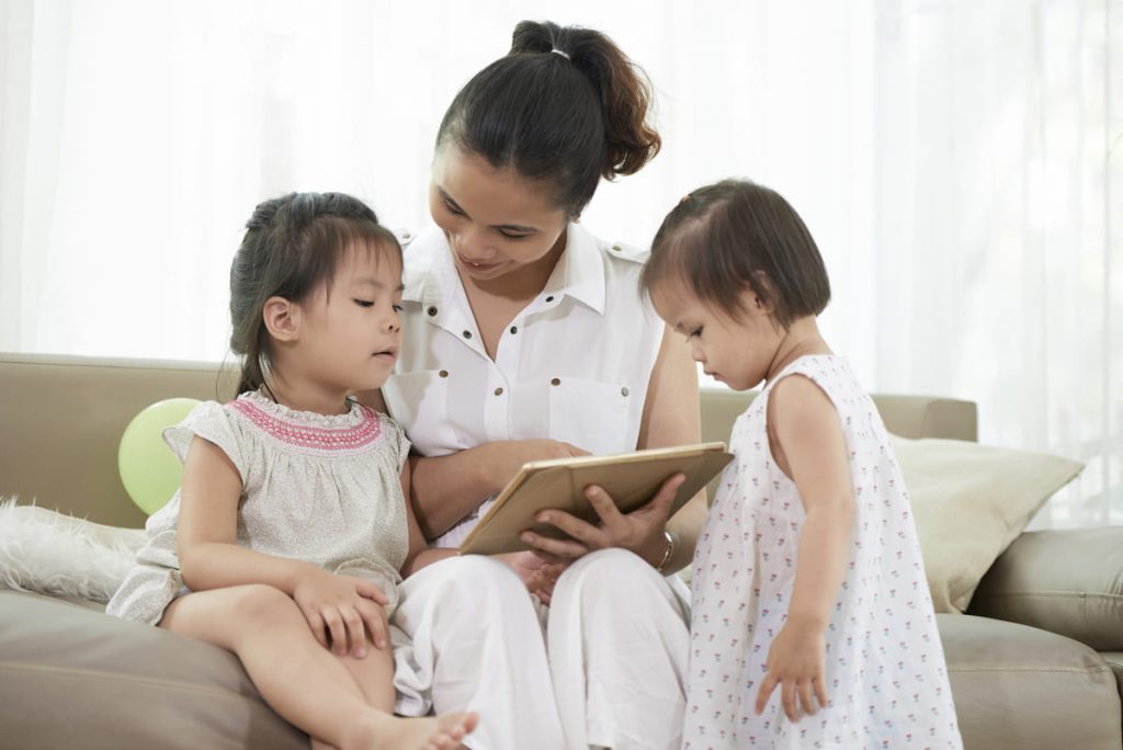 Mother and toddlers watching movie on iPad.