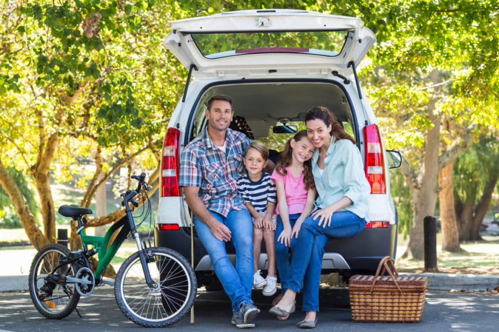 family of our sitting at the back of their van.