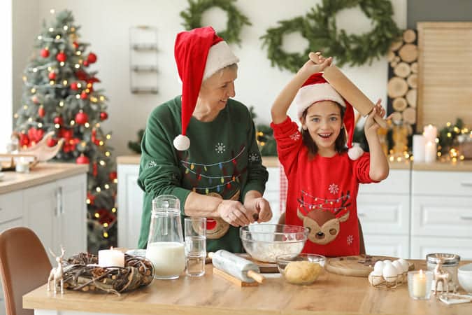 grandmother with her grand child preparing food for christmas.