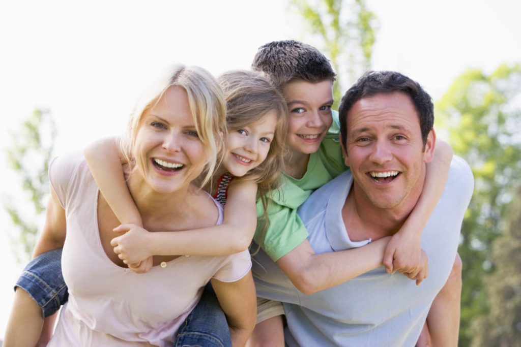 children piggy backed by their mother and father.