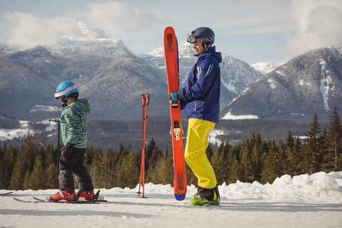 parent and kid outdoor in the snow skiing.