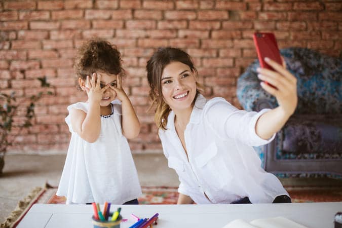 mother taking a photo together with her daughter.